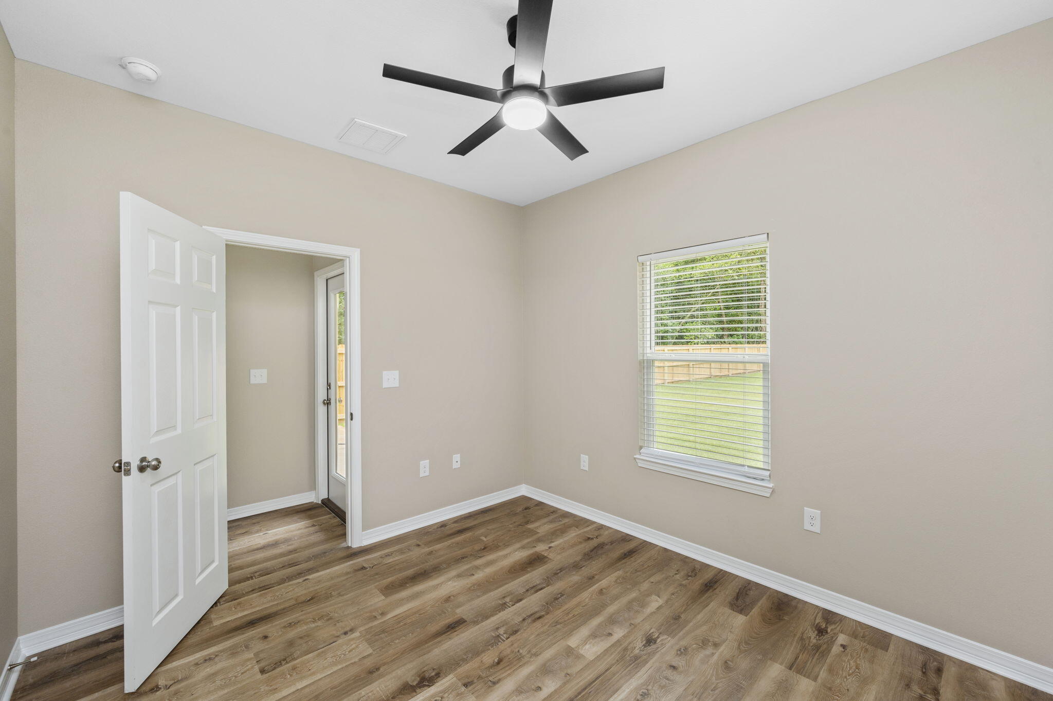 1357 East Chestnut Avenue Crestview, FL 32539 - Photo 29 of 37 a view of an empty room with wooden floor and a window