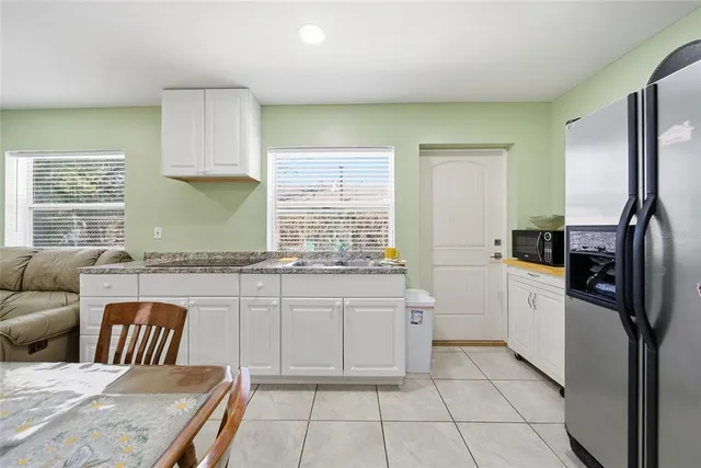 a kitchen with stainless steel appliances granite countertop a sink and dishwasher a refrigerator with white cabinets