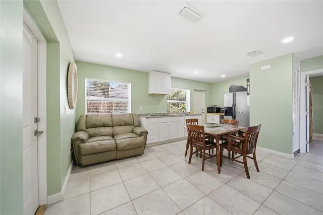 a living room with furniture and a dining table with kitchen view