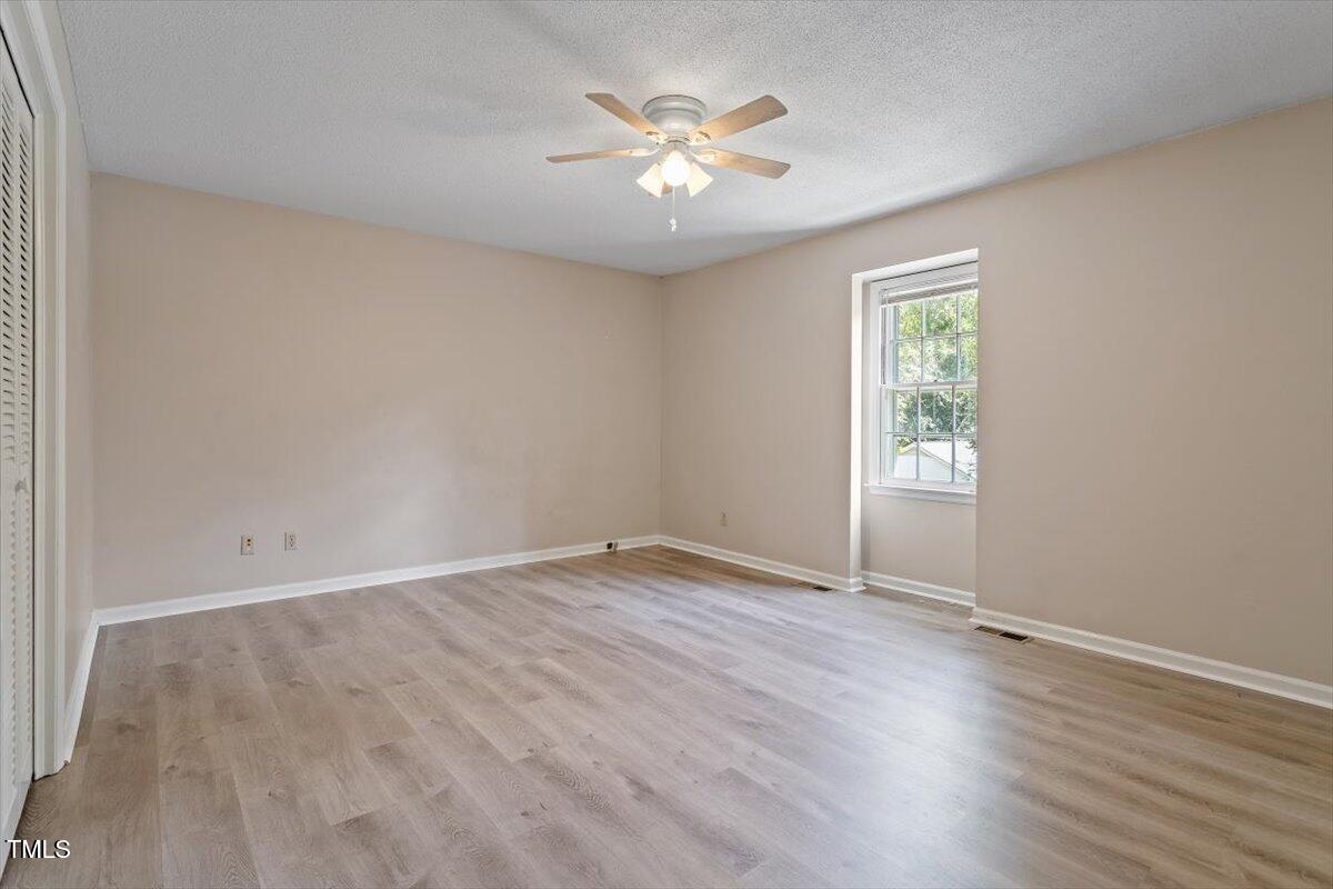 5309 Covey Court Raleigh, NC 27609 - Photo 27 of 47 an empty room with wooden floor and ceiling fan