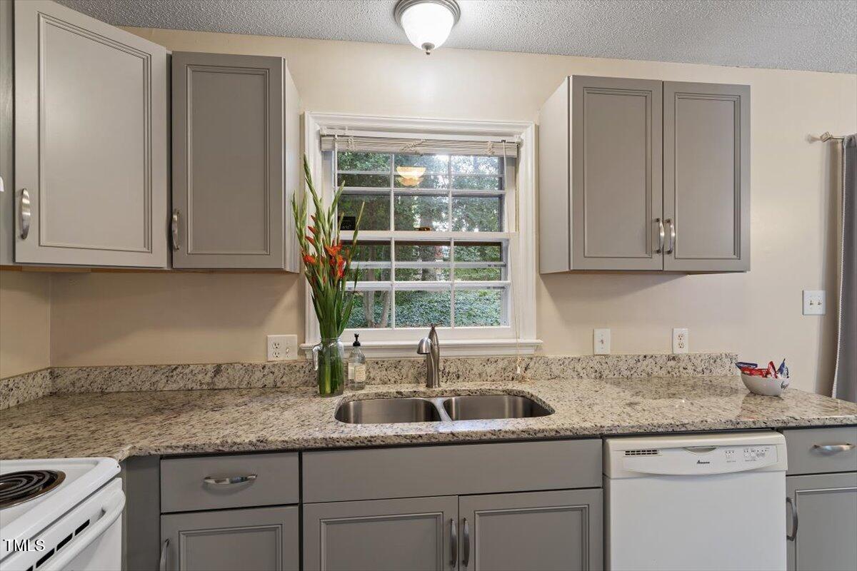 5309 Covey Court Raleigh, NC 27609 - Photo 39 of 47 a kitchen with granite countertop a sink and cabinets