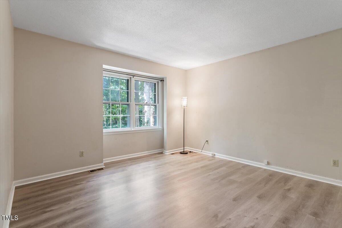 5309 Covey Court Raleigh, NC 27609 - Photo 3 of 47 a view of an empty room with wooden floor and a window