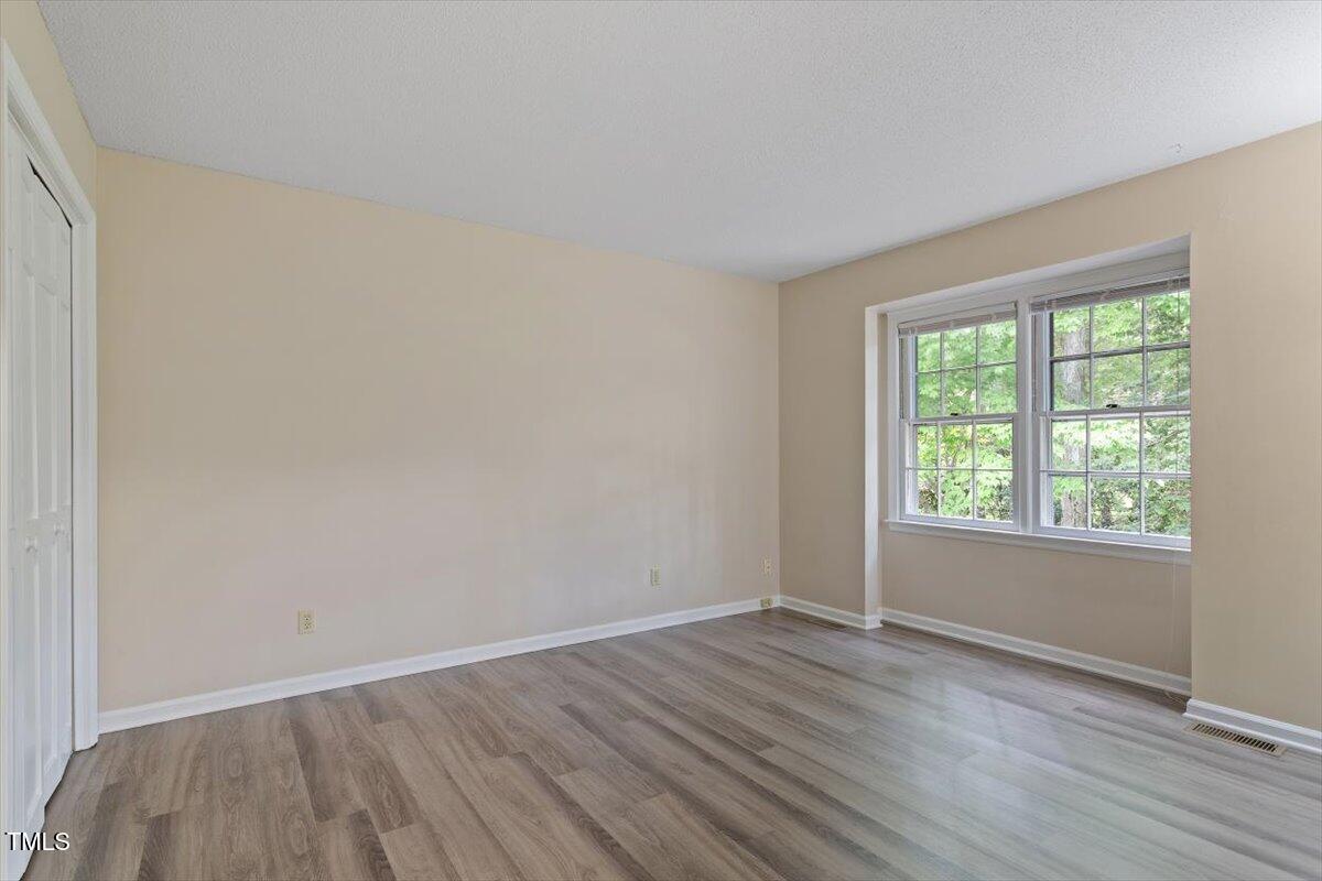5309 Covey Court Raleigh, NC 27609 - Photo 40 of 47 an empty room with wooden floor and windows