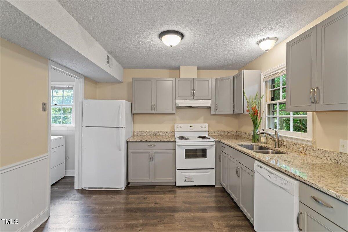 5309 Covey Court Raleigh, NC 27609 - Photo 5 of 47 a kitchen with a sink a refrigerator and white cabinets