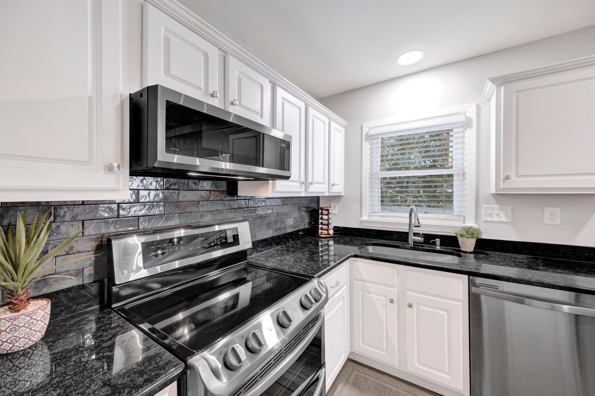 5468 Mason Road Memphis, TN 38120 - Photo 8 of 36 a kitchen with stainless steel appliances a sink a stove a microwave cabinets and a window