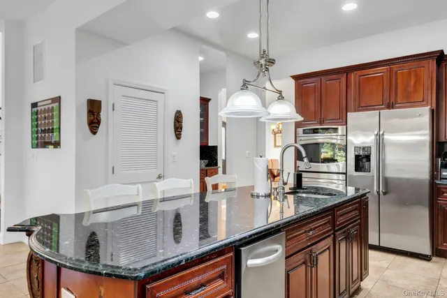 a kitchen with stainless steel appliances granite countertop a sink refrigerator and cabinets