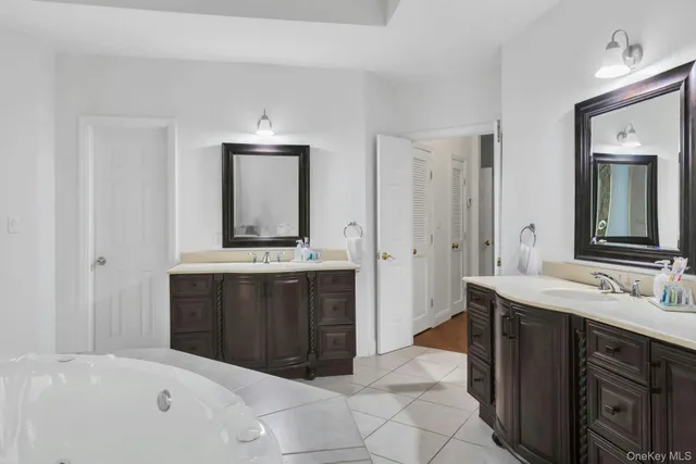 a spacious bathroom with a bathtub sink and mirror