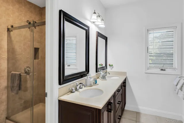 a bathroom with a double vanity sink a mirror and a shower