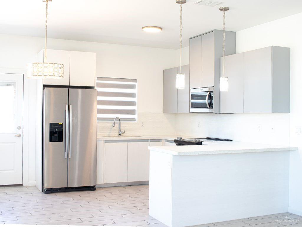 1723 West Marlin Street, Unit 3 Pharr, TX 78577 - Photo 2 of 7 a kitchen with a sink a refrigerator a microwave and cabinets