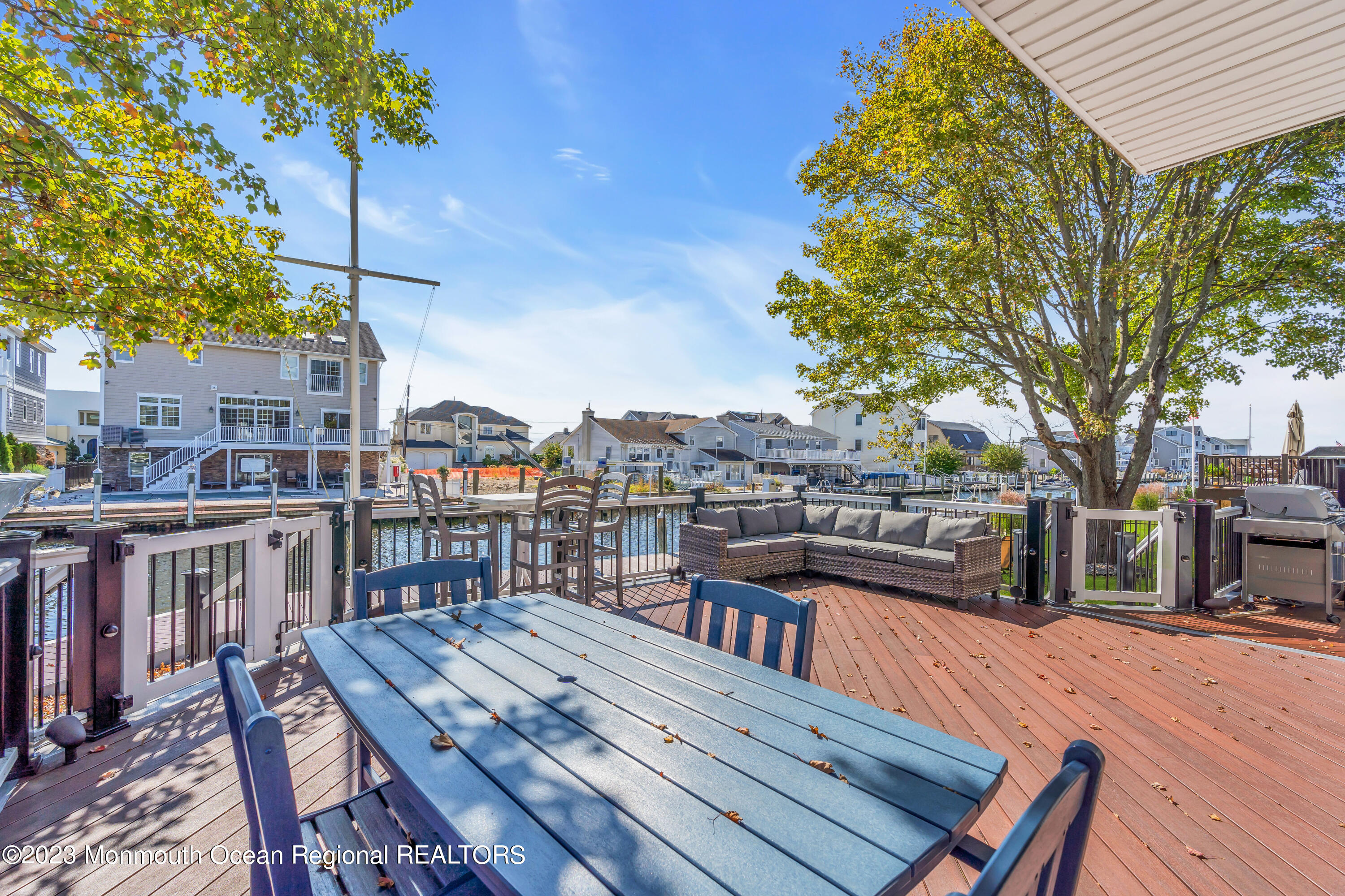 1801 Boat Point Drive Point Pleasant, NJ 08742 - Photo 58 of 76 a view of a roof deck with table and chairs a barbeque with wooden floor and fence