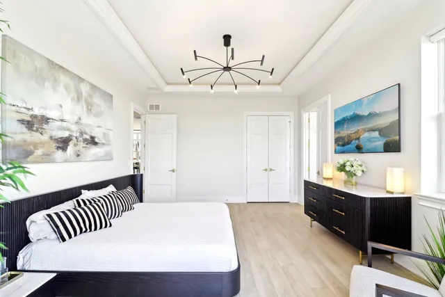 a bedroom with a bed and a chandelier