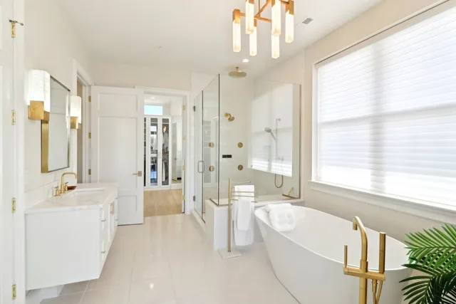 a bathroom with a tub a sink a large mirror and a shower