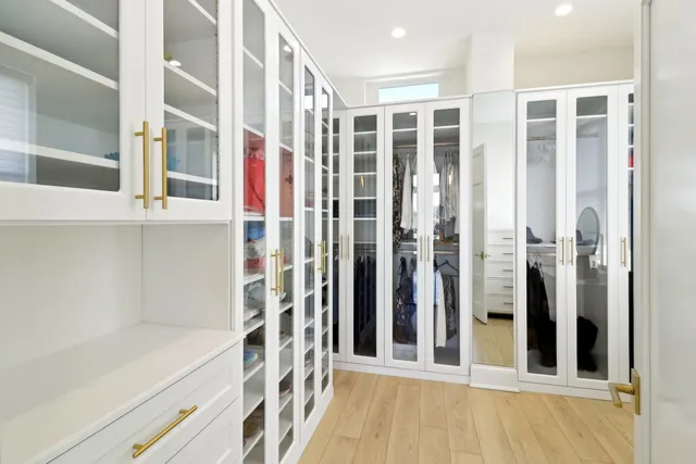 a view of walk in closet with clothes and shoes