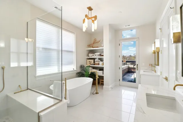 a bathroom with a tub a sink a mirror and a shower