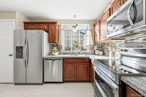 a kitchen with stainless steel appliances granite countertop a refrigerator and a sink