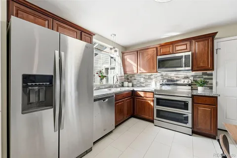 a kitchen with stainless steel appliances granite countertop a refrigerator and a stove top oven