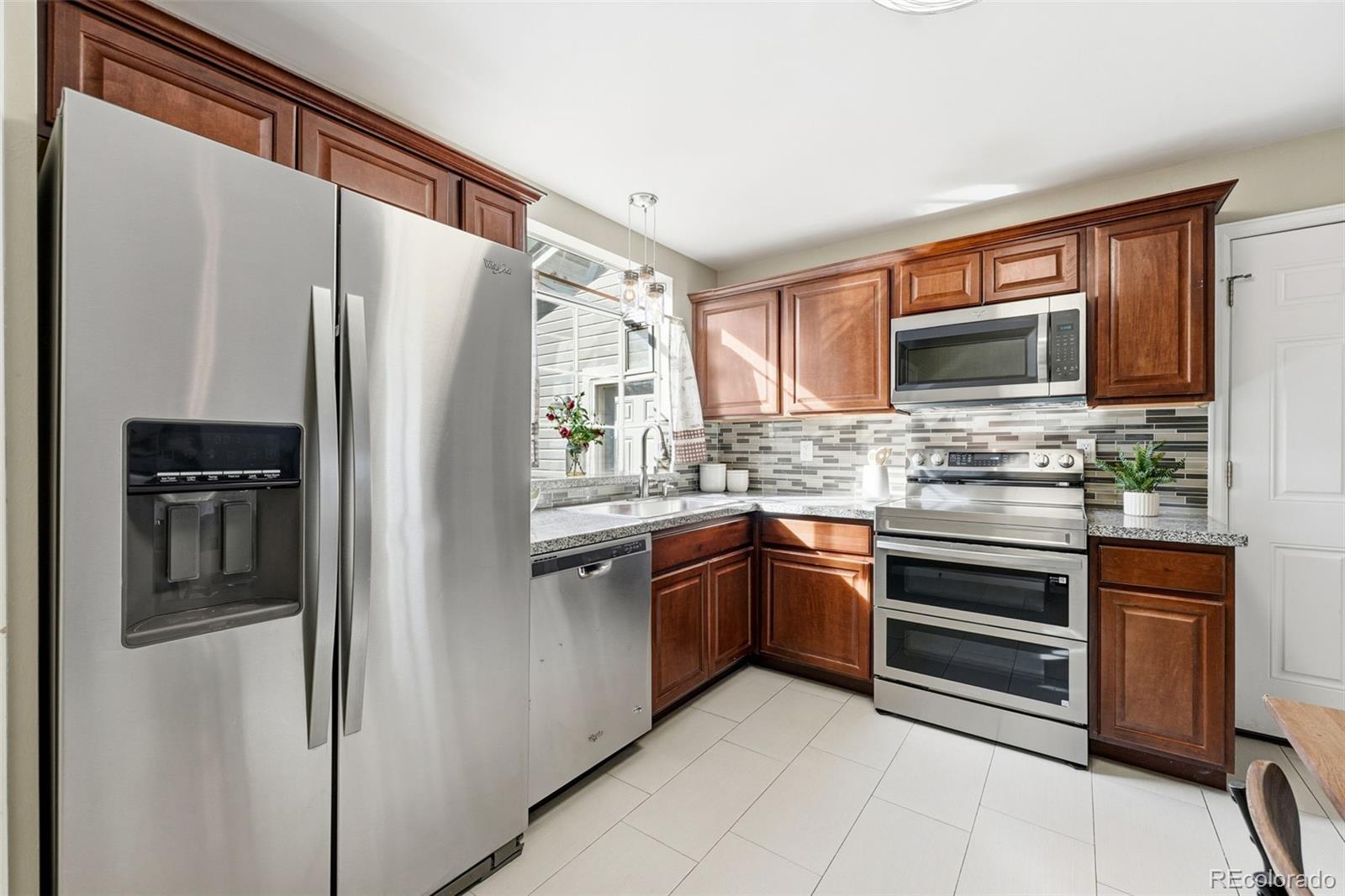 17660 Snowberry Way Parker, CO 80134 - Photo 13 of 38 a kitchen with stainless steel appliances granite countertop a refrigerator and a stove top oven