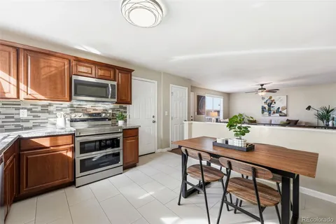 a kitchen with stainless steel appliances kitchen island granite countertop a stove a sink dishwasher and a microwave oven with wooden cabinets