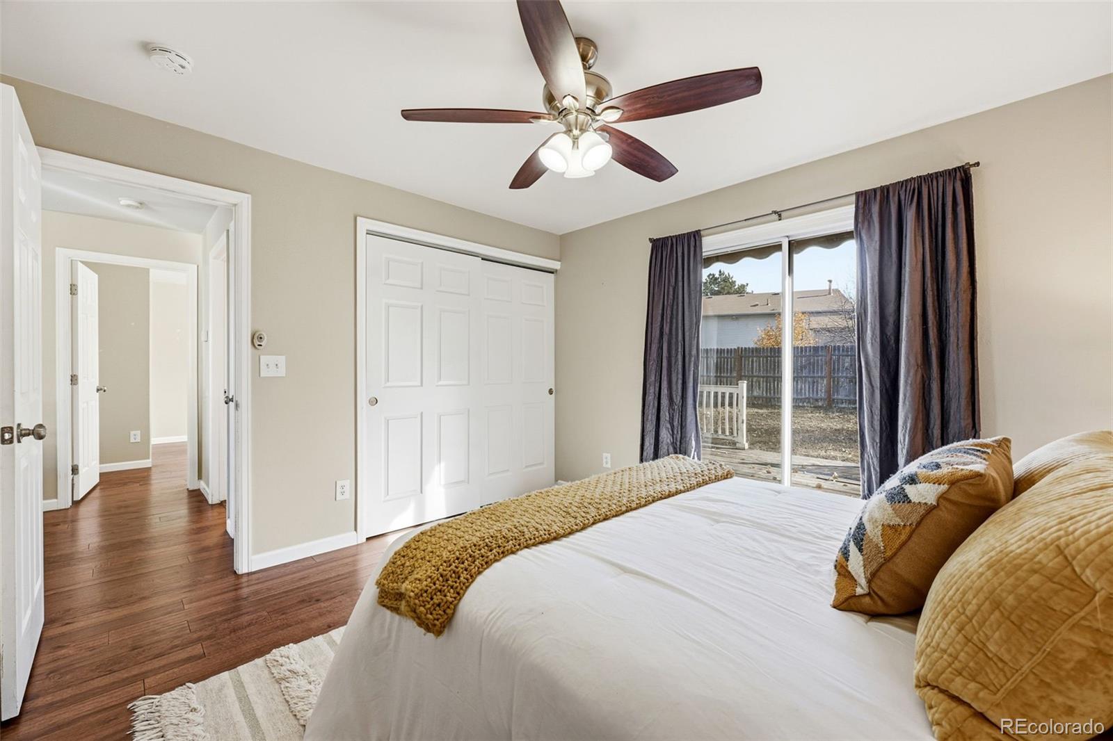 17660 Snowberry Way Parker, CO 80134 - Photo 22 of 38 a bedroom with a bed and a large window with wooden floor