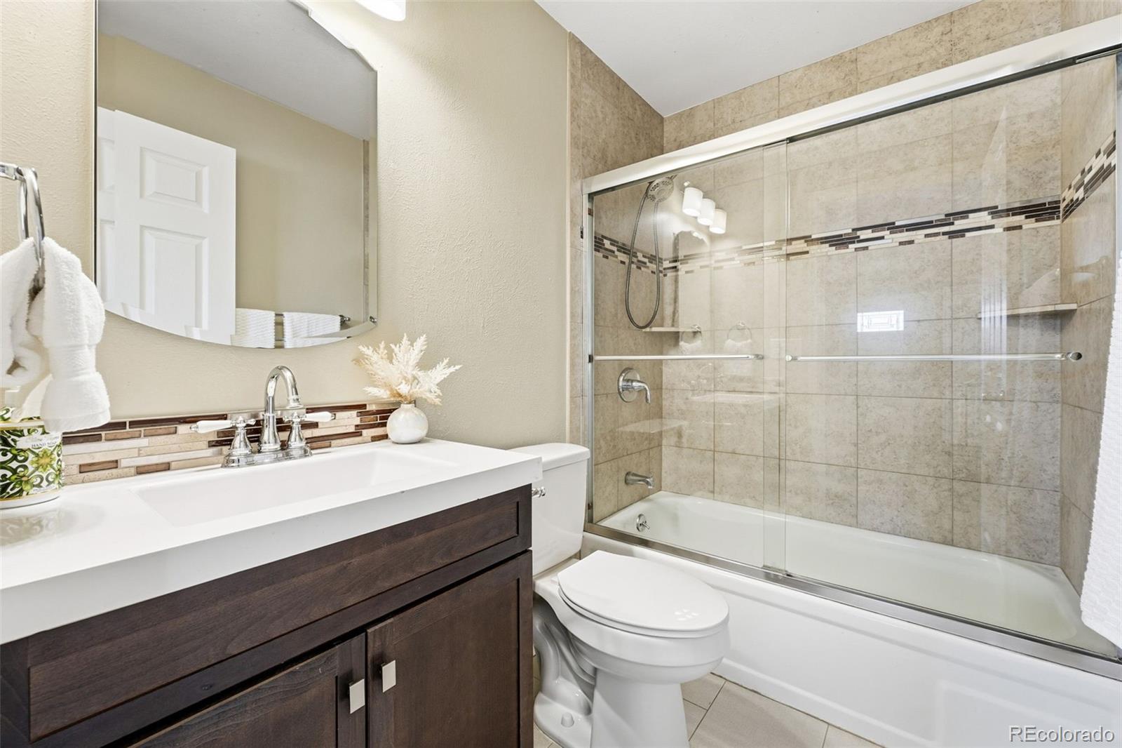 17660 Snowberry Way Parker, CO 80134 - Photo 23 of 38 a bathroom with a sink a toilet and shower