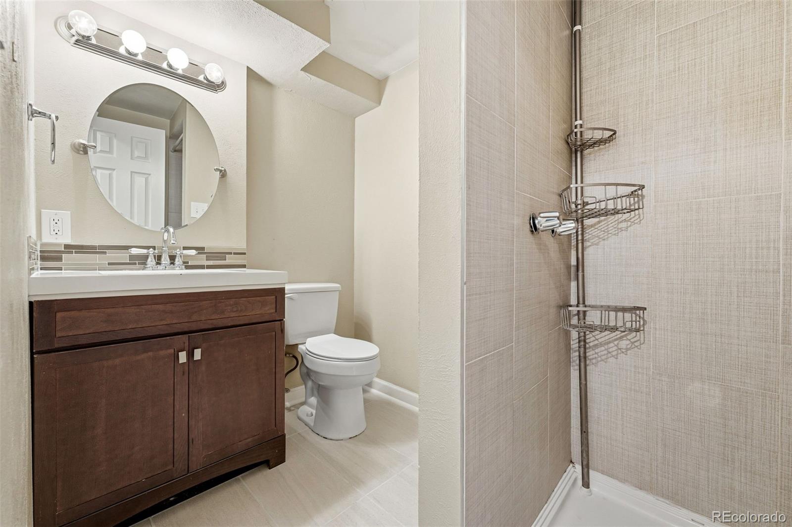 17660 Snowberry Way Parker, CO 80134 - Photo 26 of 38 a bathroom with a toilet sink and mirror