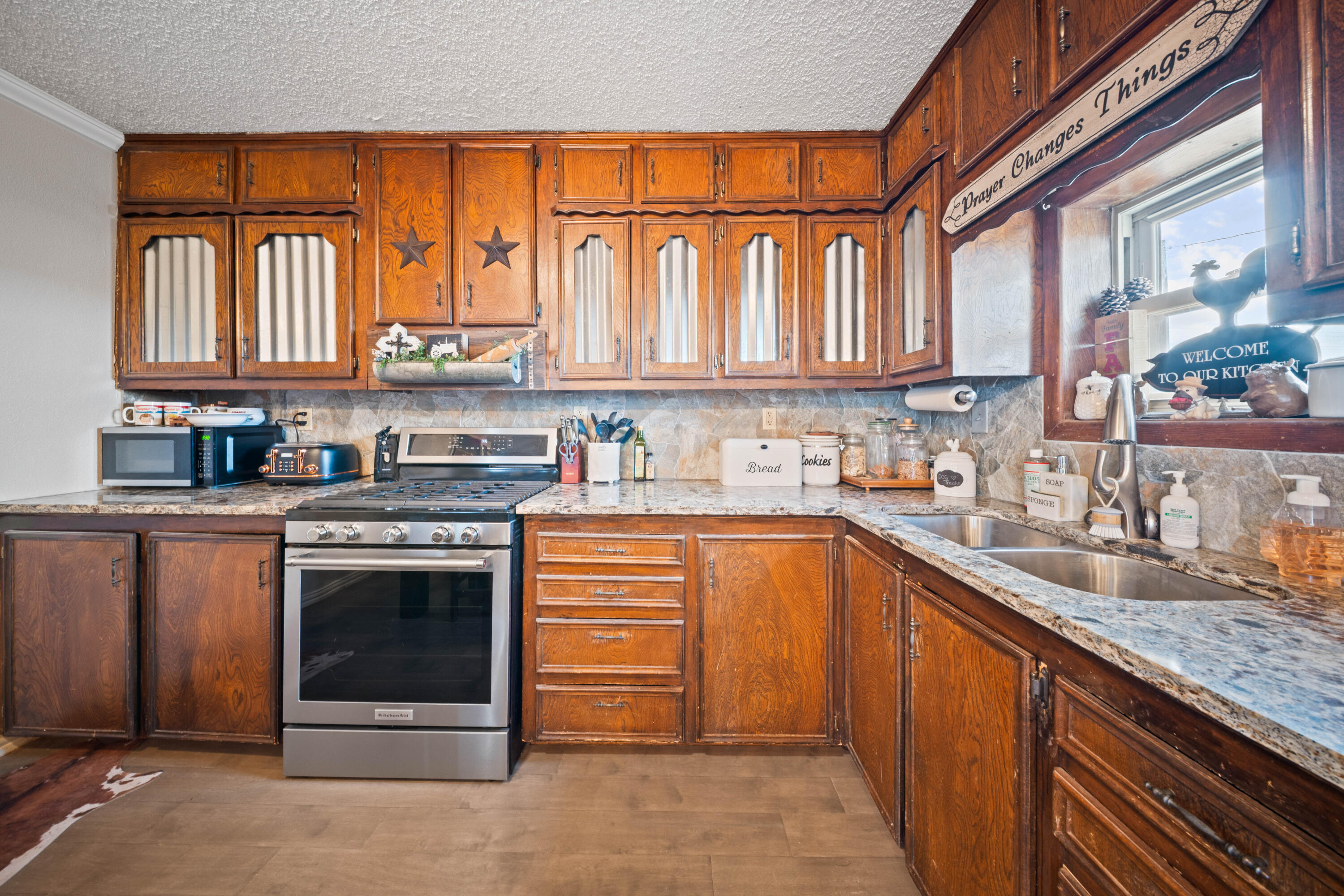 3725 Hawk Road Ropesville, TX 79358 - Photo 12 of 39 a kitchen with stainless steel appliances granite countertop a stove a sink and a microwave