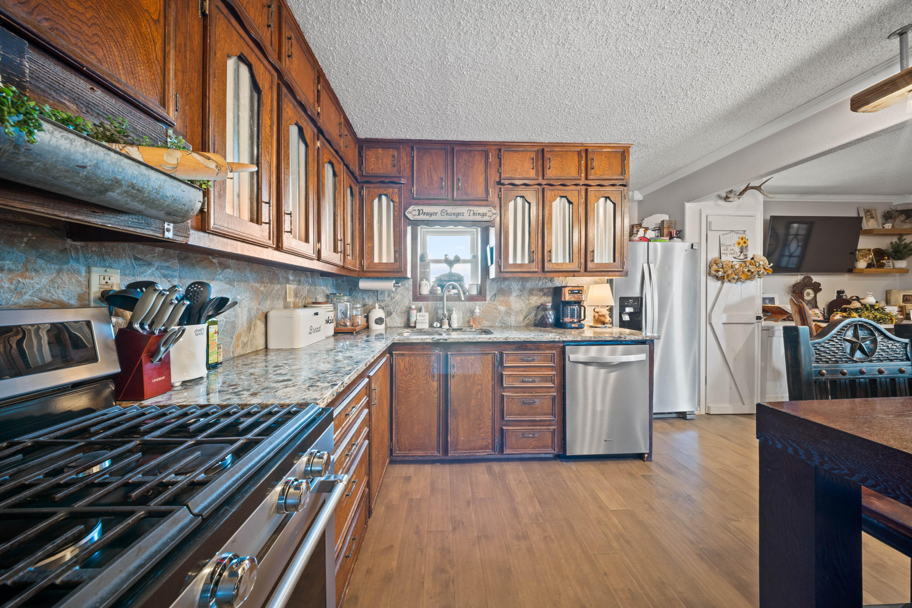 3725 Hawk Road Ropesville, TX 79358 - Photo 13 of 39 a kitchen with stainless steel appliances granite countertop a stove top oven a sink dishwasher and cabinets with wooden floor
