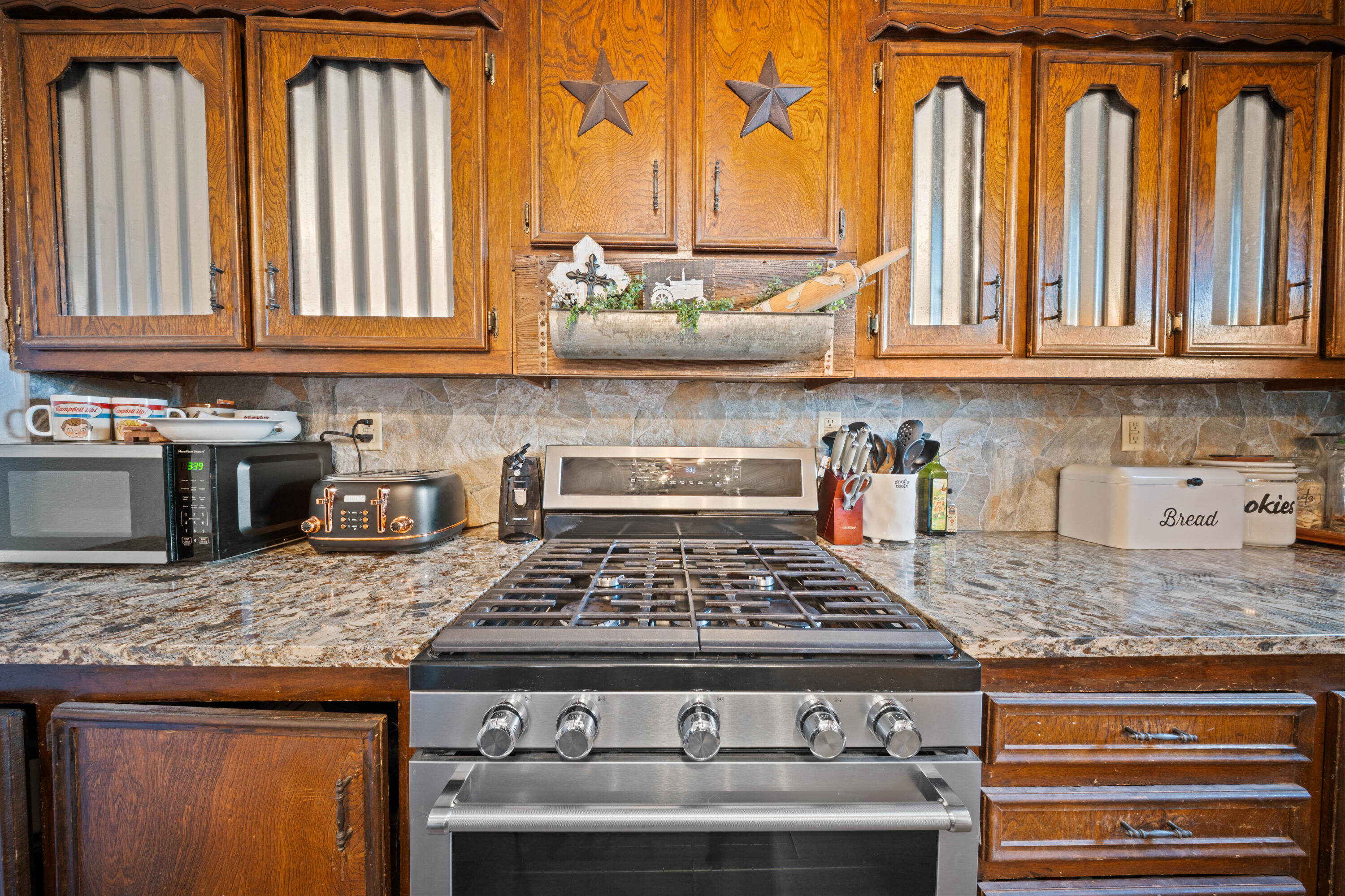 3725 Hawk Road Ropesville, TX 79358 - Photo 14 of 39 a kitchen with granite countertop a sink a stove and cabinets