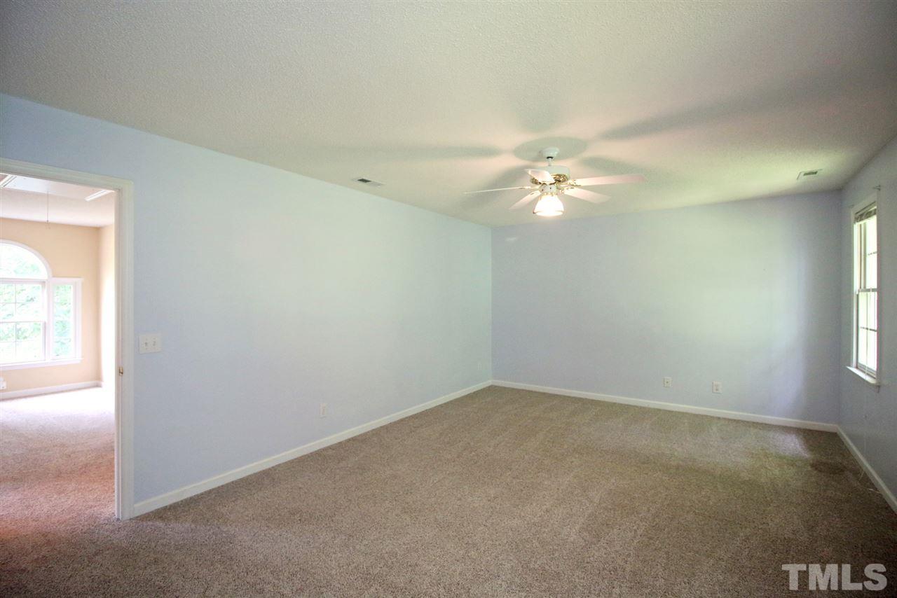 8520 Clivedon Drive Raleigh, NC 27615 - Photo 14 of 25 an empty room with windows and ceiling fan