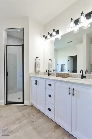 a bathroom with a double vanity sink and a mirror