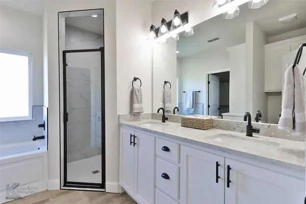a bathroom with a granite countertop sink a large mirror and a bathtub