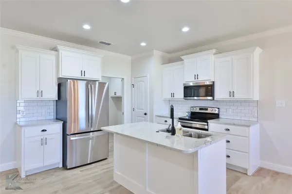 a kitchen with stainless steel appliances a refrigerator stove microwave and sink
