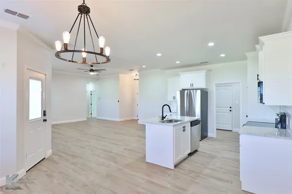 a kitchen with stainless steel appliances kitchen island a refrigerator and a sink