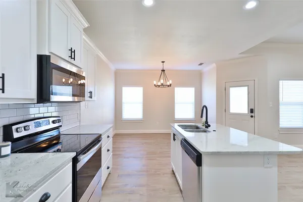 a kitchen with stainless steel appliances granite countertop a sink and a stove