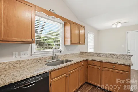 a kitchen with granite countertop cabinets sink and window