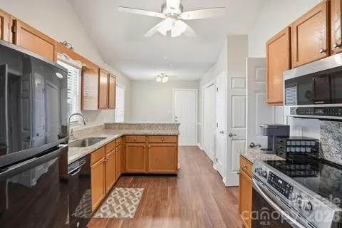 a large kitchen with stainless steel appliances granite countertop a stove and a sink