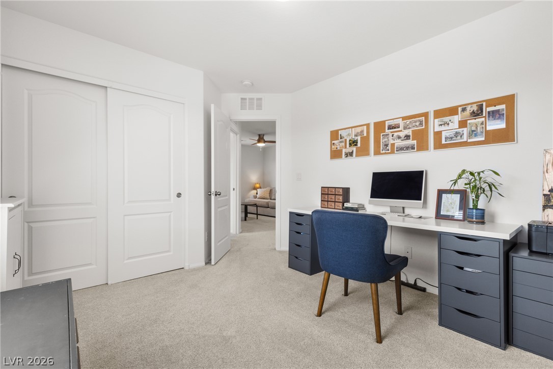 891 Earth Luster Road Las Vegas, NV 89178 - Photo 25 of 48 A dedicated home office space features plush carpeting and a bright, functional workspace.