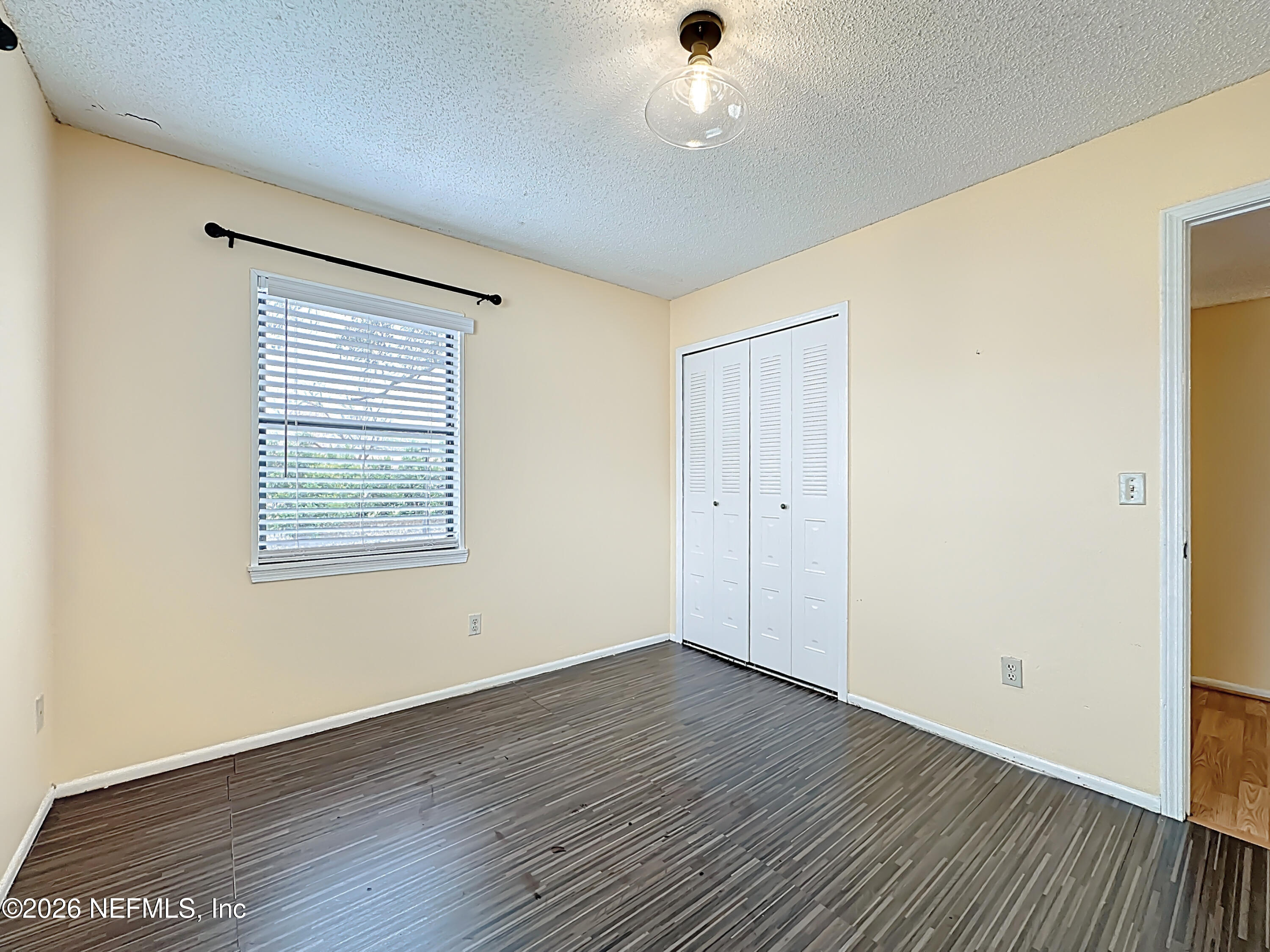 3410 Ricky Court Jacksonville, FL 32223 - Photo 19 of 37 an empty room with wooden floor and windows