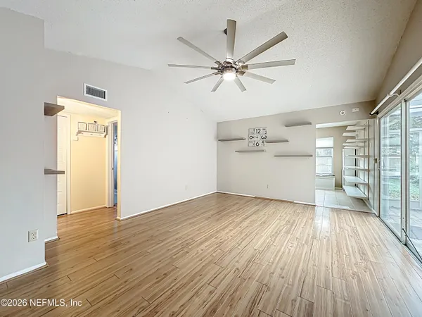 an empty room with wooden floor and windows