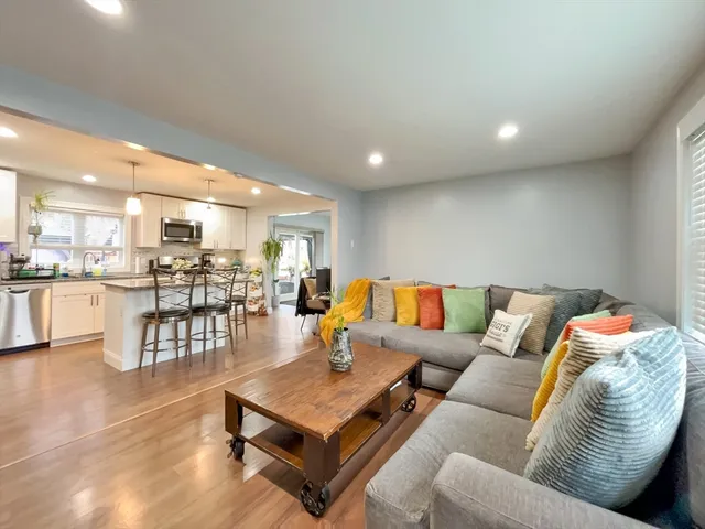 a living room with furniture kitchen view and a table