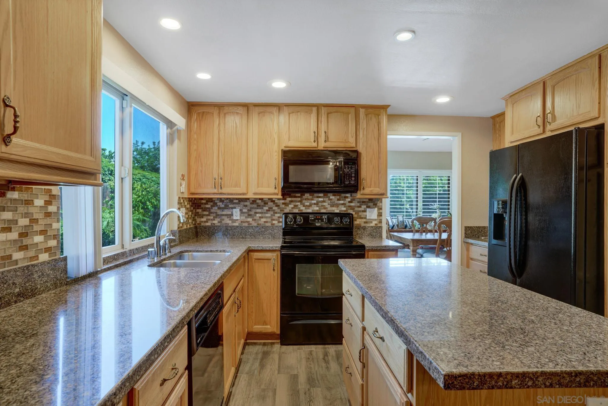 3006 Gayla Court Spring Valley, CA 91978 - Photo 14 of 39 a kitchen with a stove a sink a microwave a refrigerator and cabinets