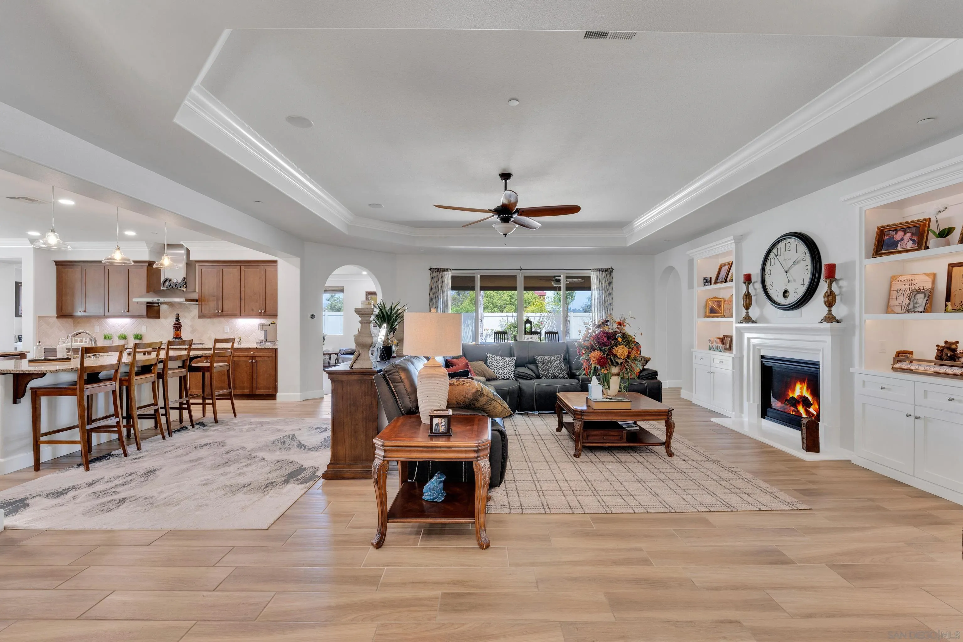5620 Rancho Del Caballo Bonsall, CA 92003 - Photo 12 of 62 a living room with furniture a fireplace and a kitchen view