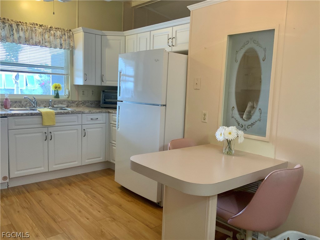 15550 Burnt Store Road, Unit 89 Punta Gorda, FL 33955 - Photo 4 of 28 a kitchen with stainless steel appliances granite countertop a table chairs sink and cabinets