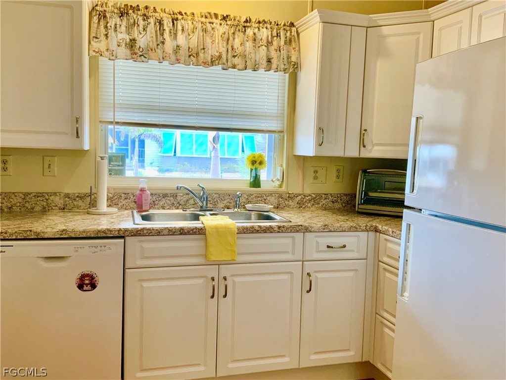 15550 Burnt Store Road, Unit 89 Punta Gorda, FL 33955 - Photo 5 of 28 a kitchen with granite countertop a sink a stove and cabinets