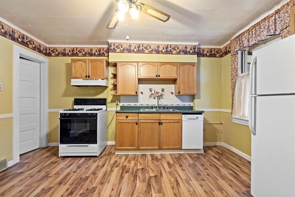 1140 Race Street McKees Rocks, PA 15136 - Photo 13 of 25 a kitchen with granite countertop a sink cabinets and stainless steel appliances