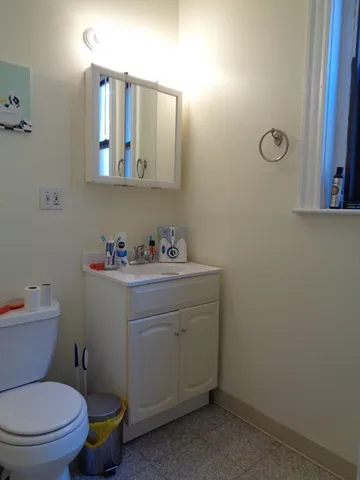 a bathroom with a toilet sink and mirror