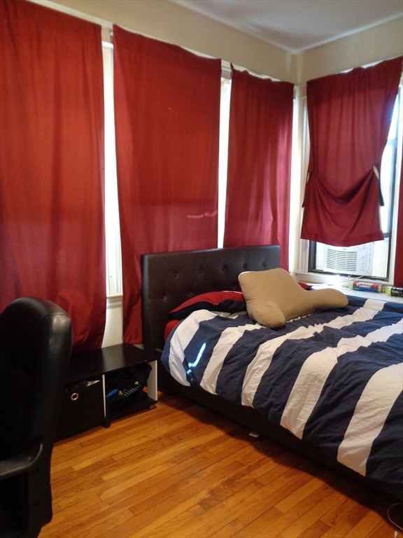 40 Carlton Street, Unit 5 Brookline, MA 02446 - Photo 5 of 6 a bedroom with a bed and a chair