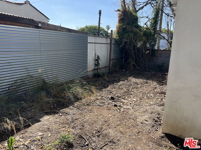 a view of a white house with a yard and potted plants