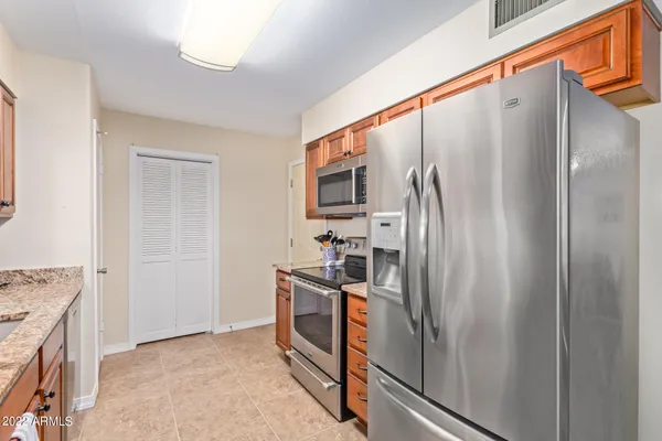 a kitchen with stainless steel appliances granite countertop a refrigerator and a stove