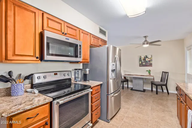 a kitchen with stainless steel appliances granite countertop a stove refrigerator sink and microwave
